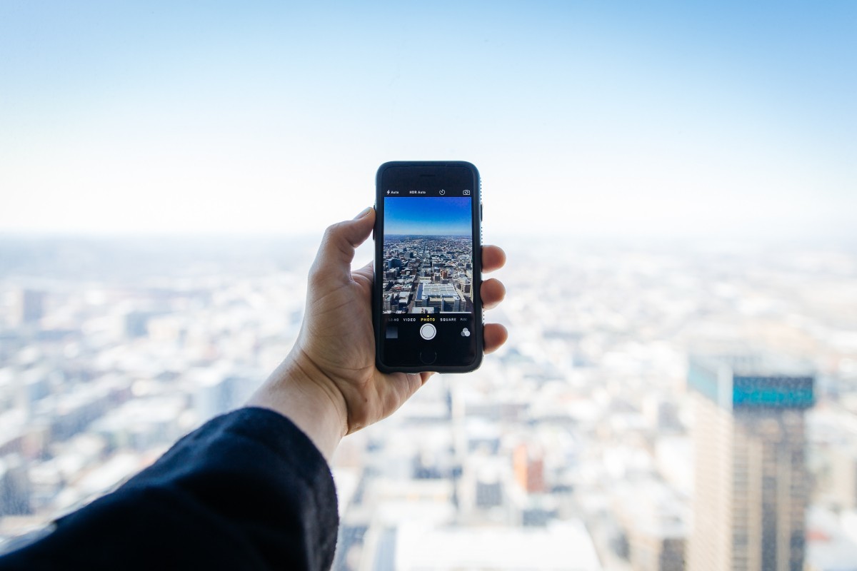 Phone in the hand of a person overlooking a city